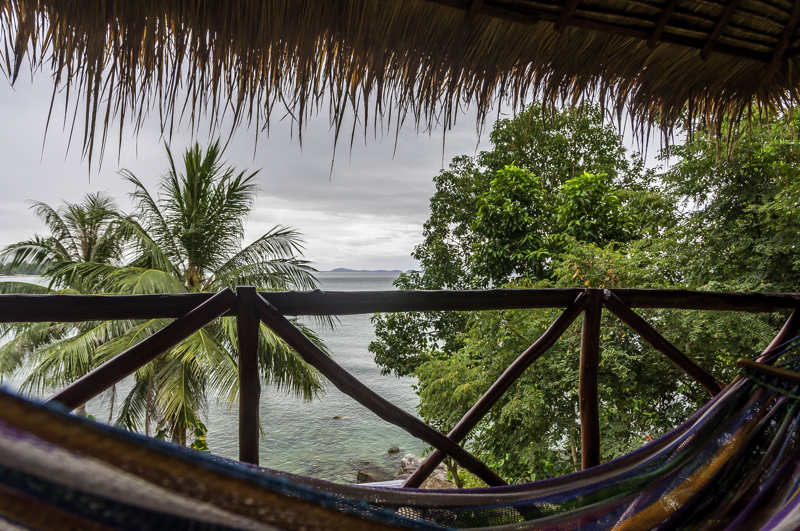Photo of a hammock with trees and water in the background